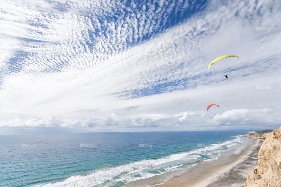 Bliss. Paragliders over Black's beach in La Jolla on a bright cloudy day.