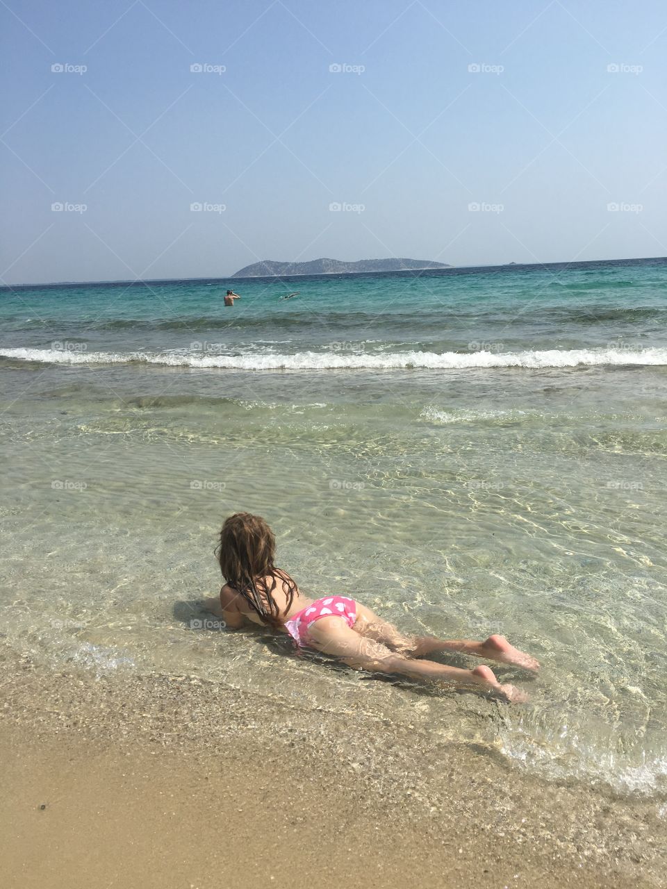 Little girl on the beach enjoying shallow water