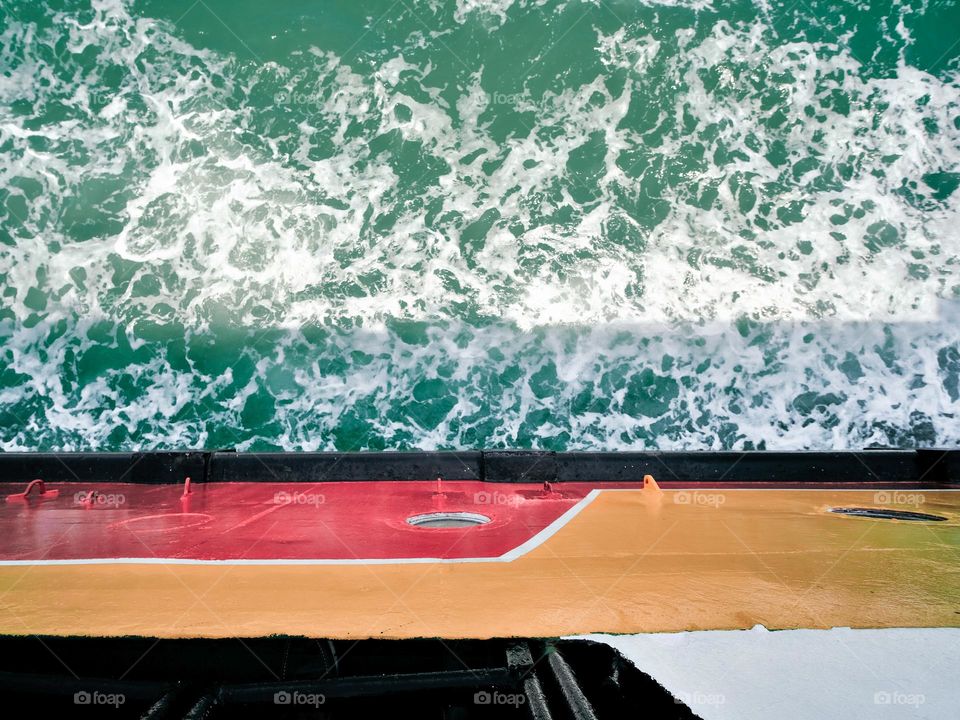 Looking down to the sea waves below from the ferry boat