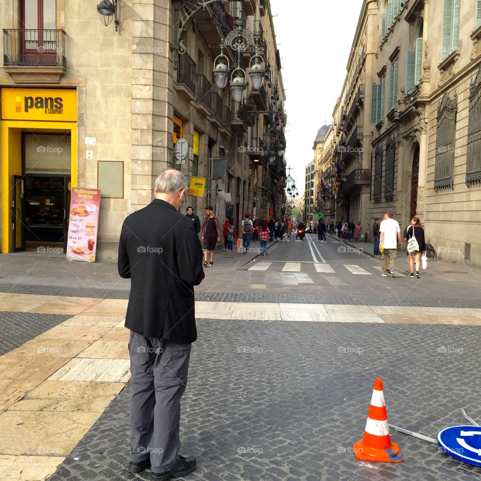 Older man standing on the middle of the street 