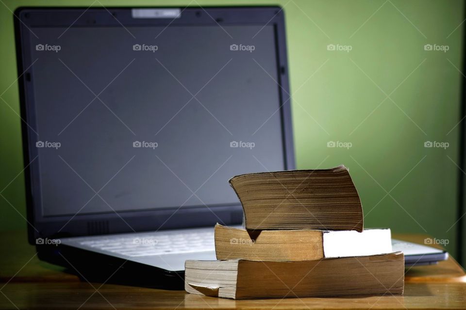 stack of books and a laptop computer