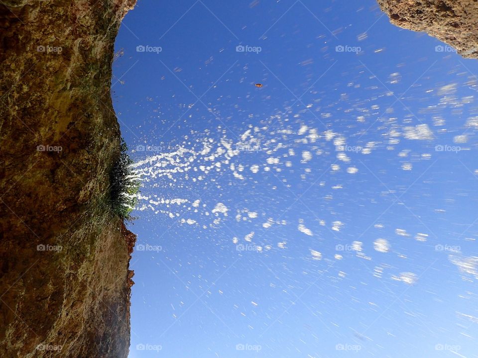 Falling water drops with blue sky