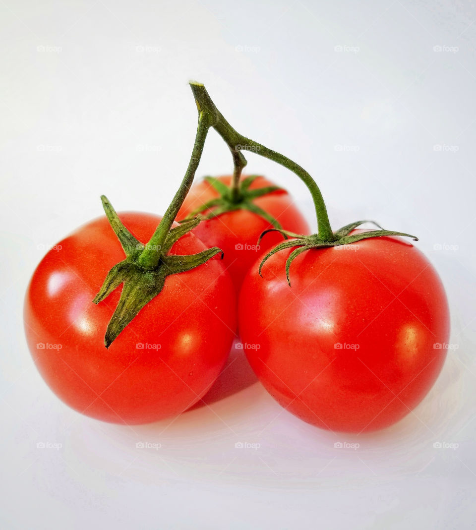 Three tomatoes on a white background