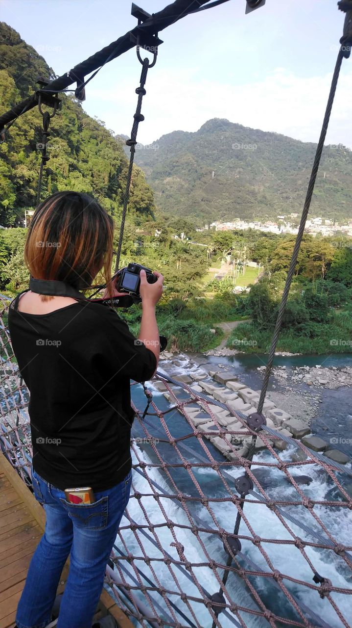 standing front if the river, while checking the perfect capture.