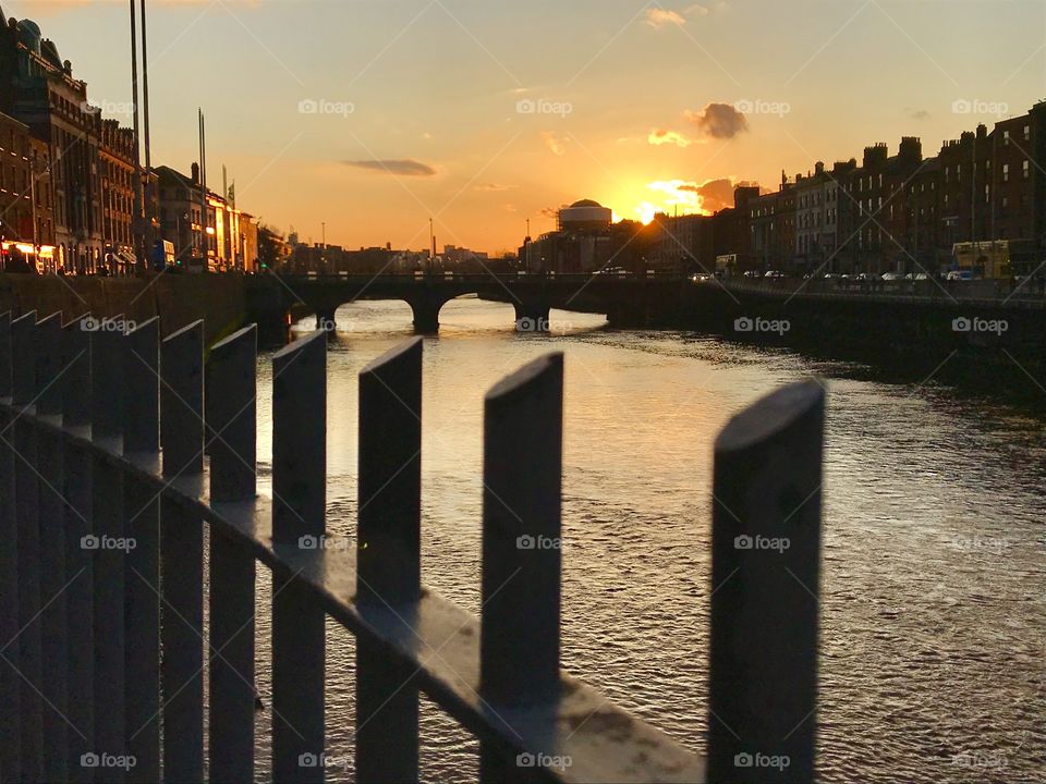 Sun setting behind buildings along the Liffy River in Dublin, Ireland