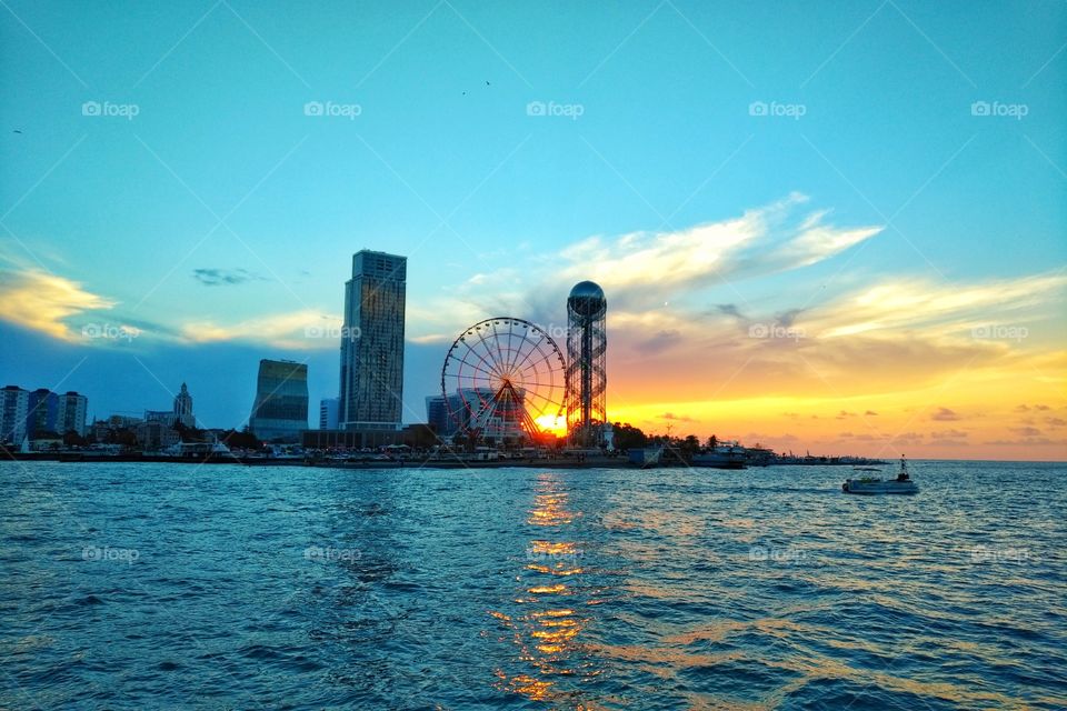 Panorama of Illuminated Resort city Batumi. Bright Evening Sky. View From Sea Beach To Illuminated Cityscape