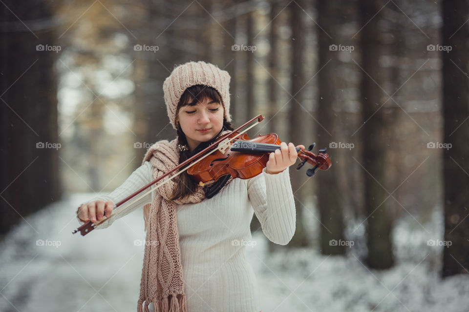 Teenage girl portrait with violin in winter park