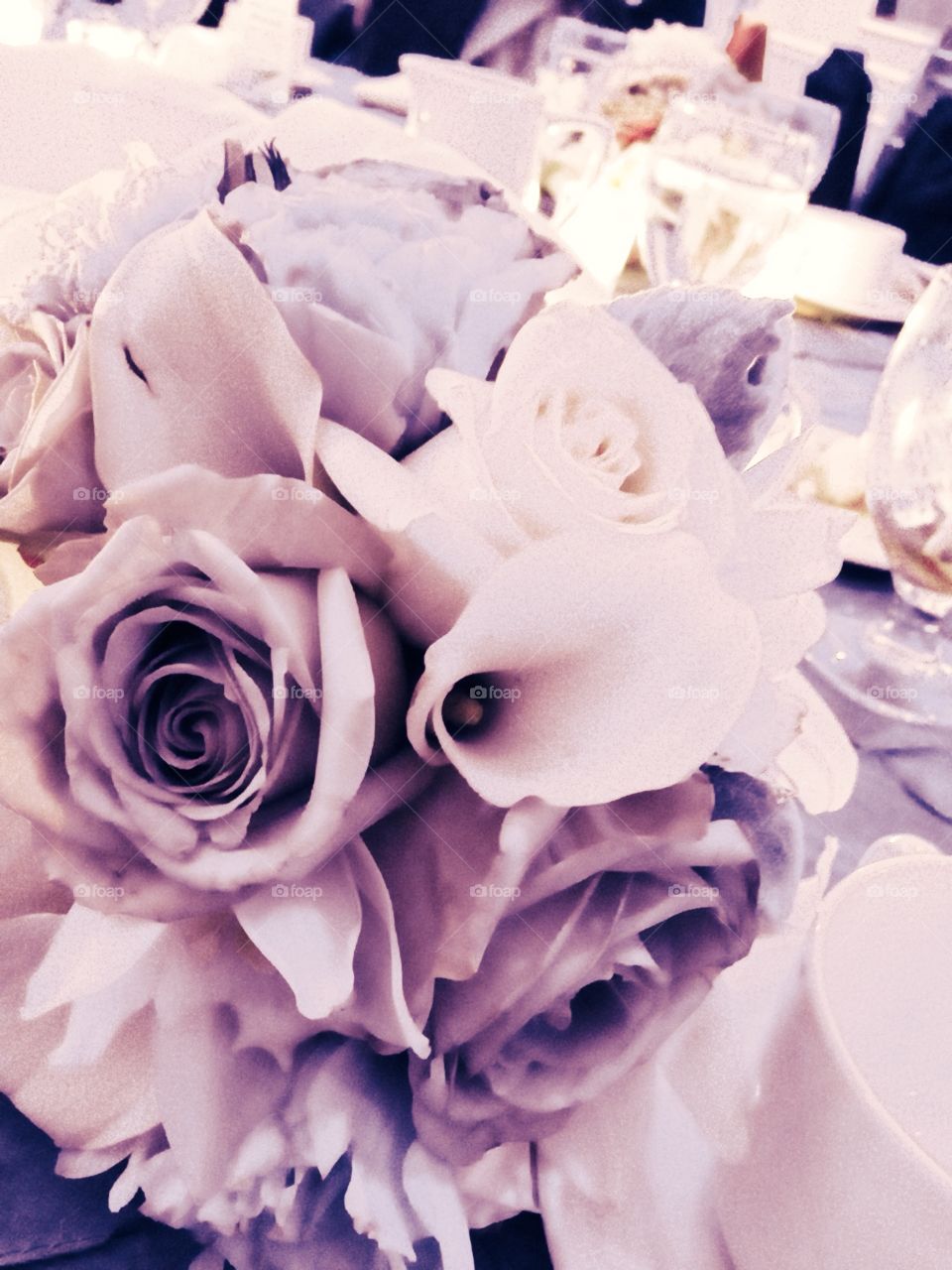 A bouquet of flowers from a wedding. It is on the table and beautiful. 