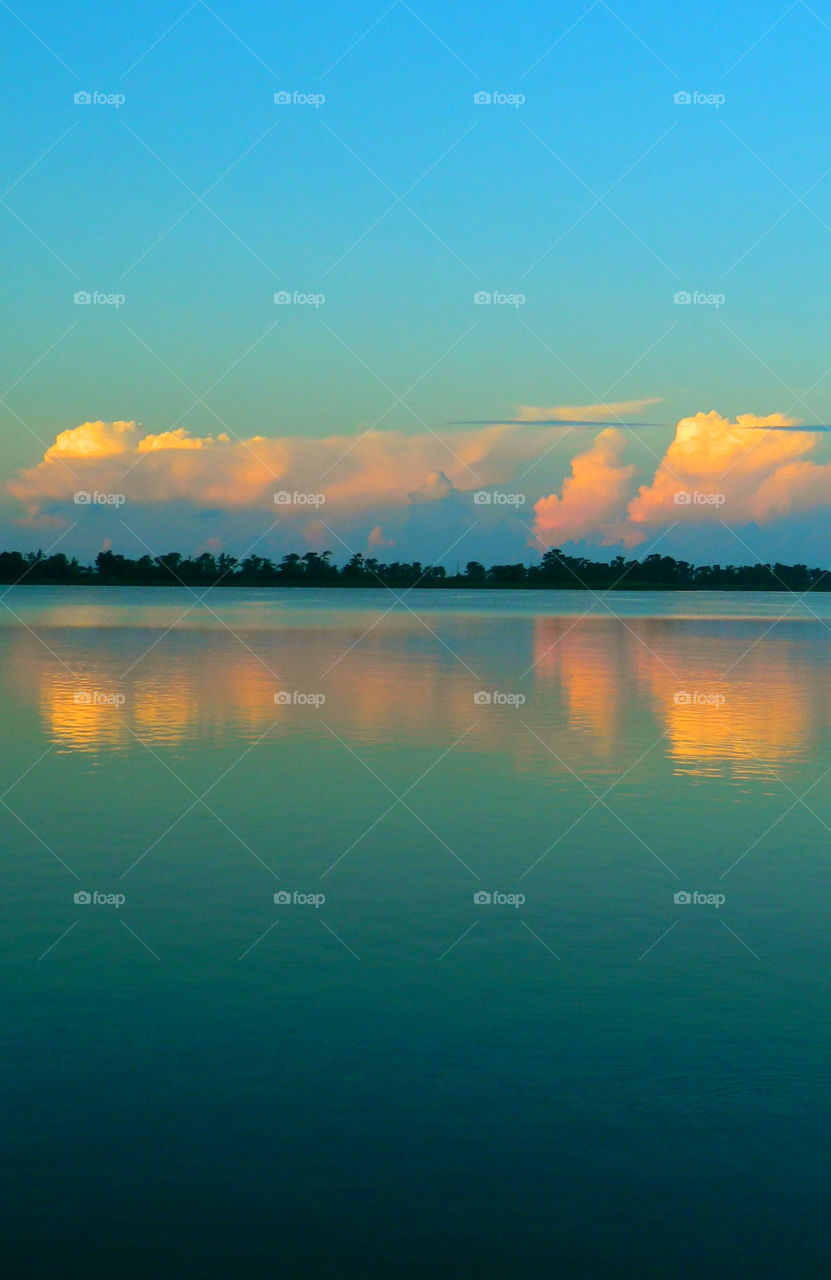 How clear, how lovely bright, what a beautiful sight! This breathtaking sunrise painted the sky and clouds with pinks and blues as it shimmered across the cool morning bay!