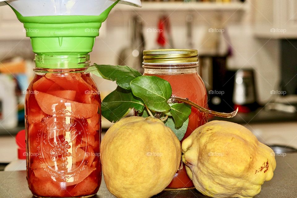 Grouping of fresh preserves and partially filled jar with preserve funnel; country fresh quince fruit preserves and sauce 