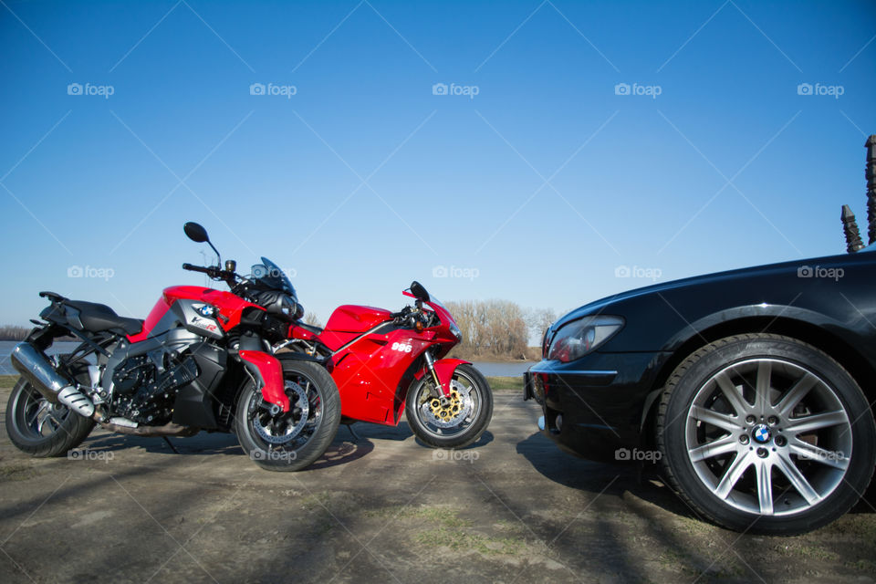 Sports motorcycles and sport car near river