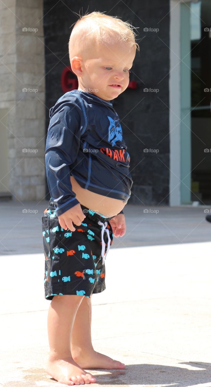 Cute little boy looking at the pool 