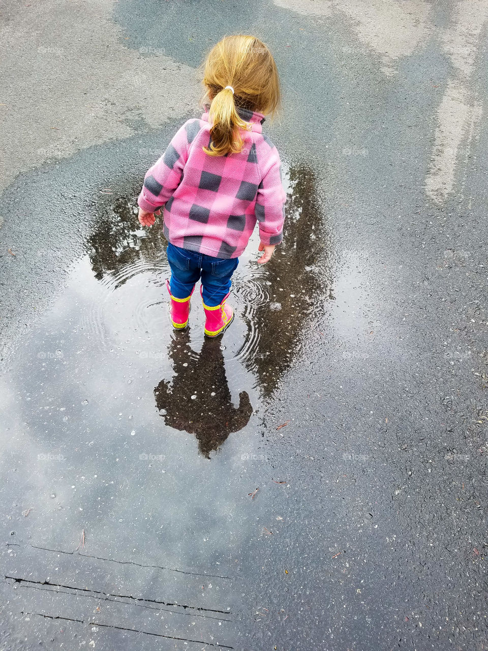 Little girl enjoying a puddle