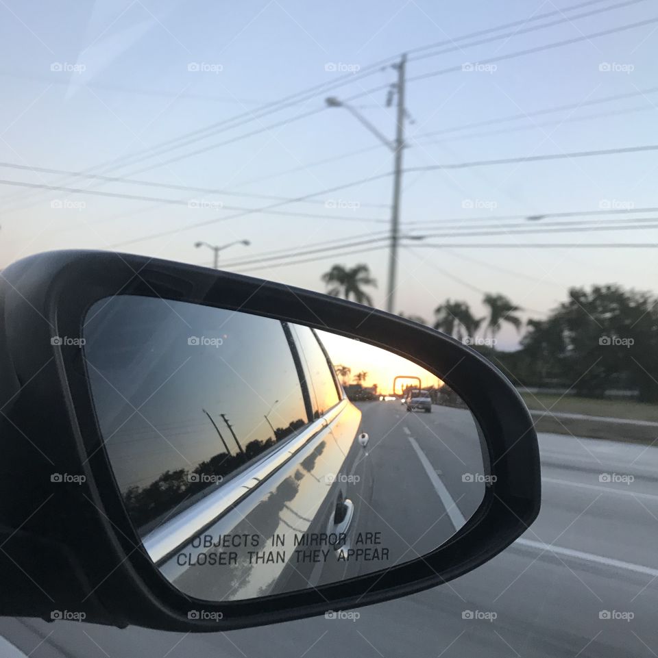 Beautiful orange sunset in rear view mirror 