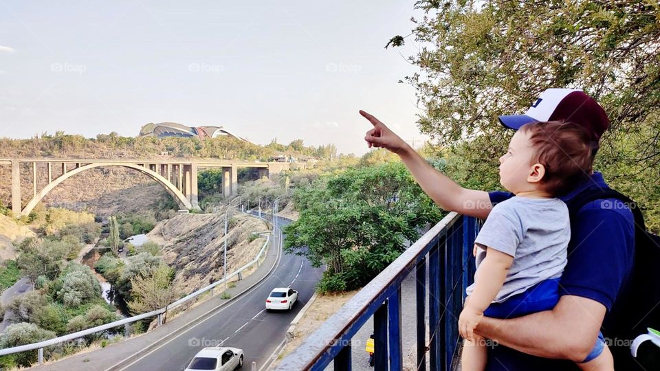 A father shows the city to his baby in his arms