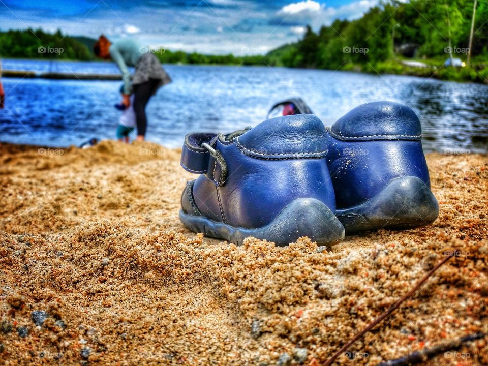 Lonely shoes . barbecue by a lake and splashing water 