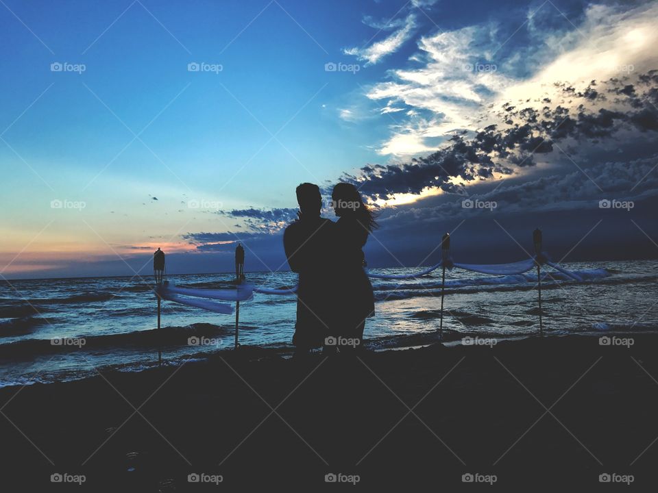 Silhouette of a Couple Embracing on the Beach Against a Beautiful Sunset