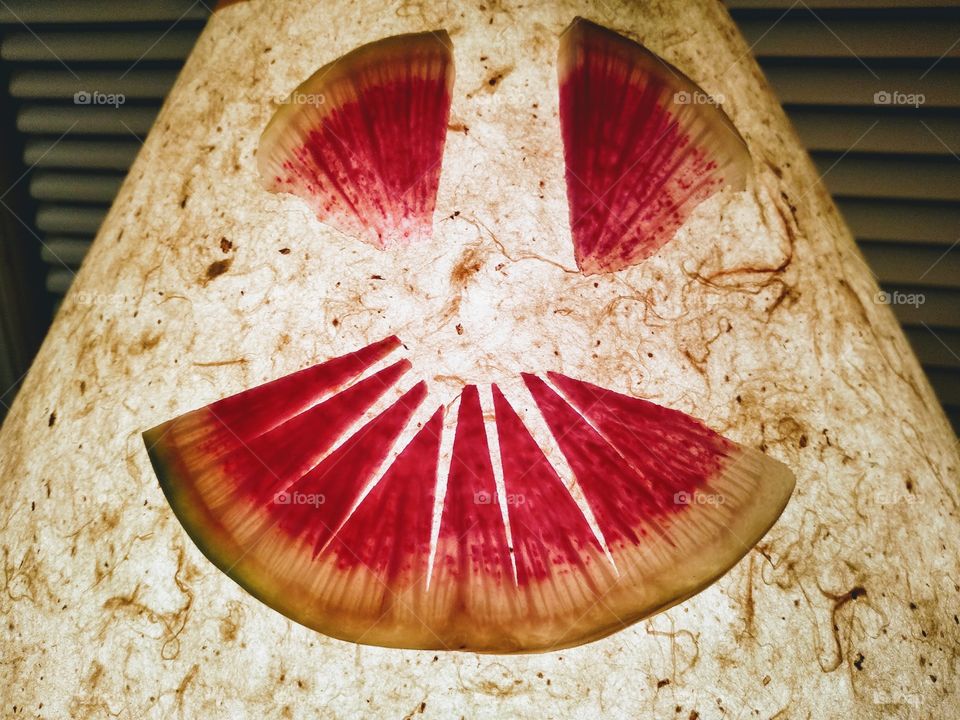 face made out of watermelon radish slices on a lamp