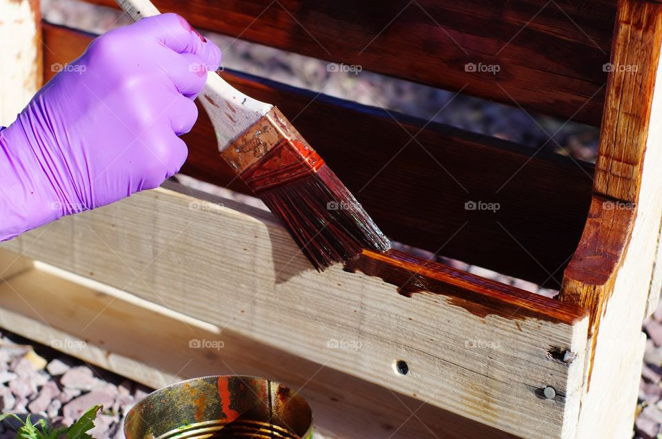 Applying wood stain to a homemade wine rack.