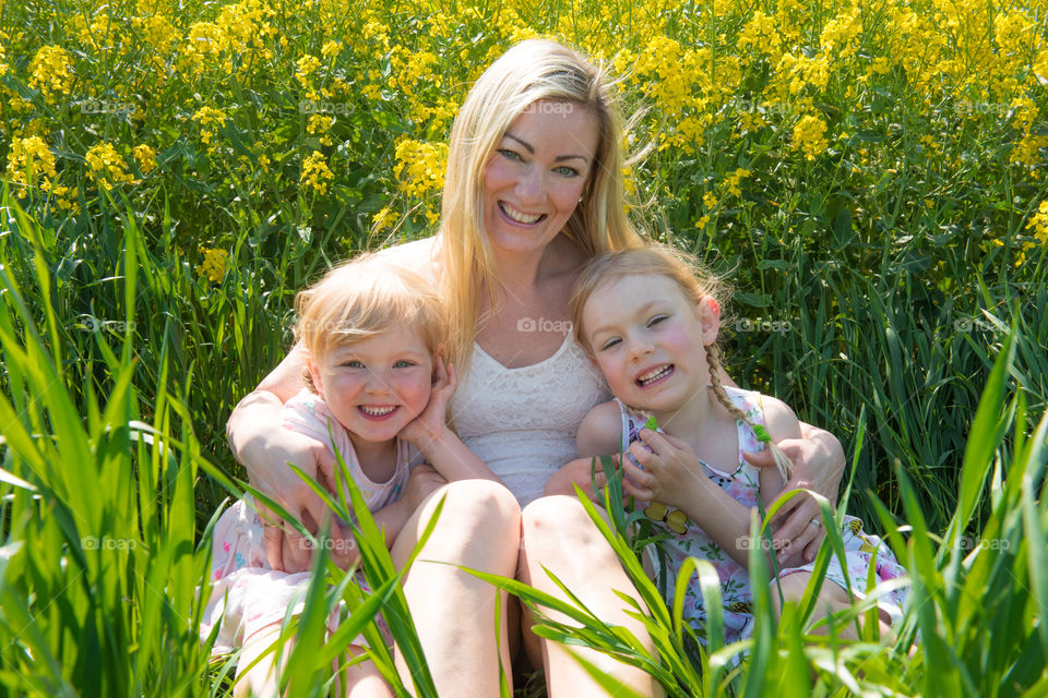 Mother with her two cute doughters posing in a raps field outside Malmö in Sweden.