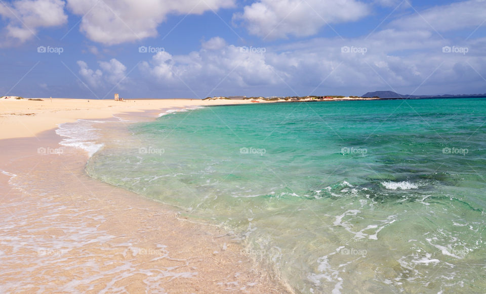 Scenic view of beach against cloudy sky