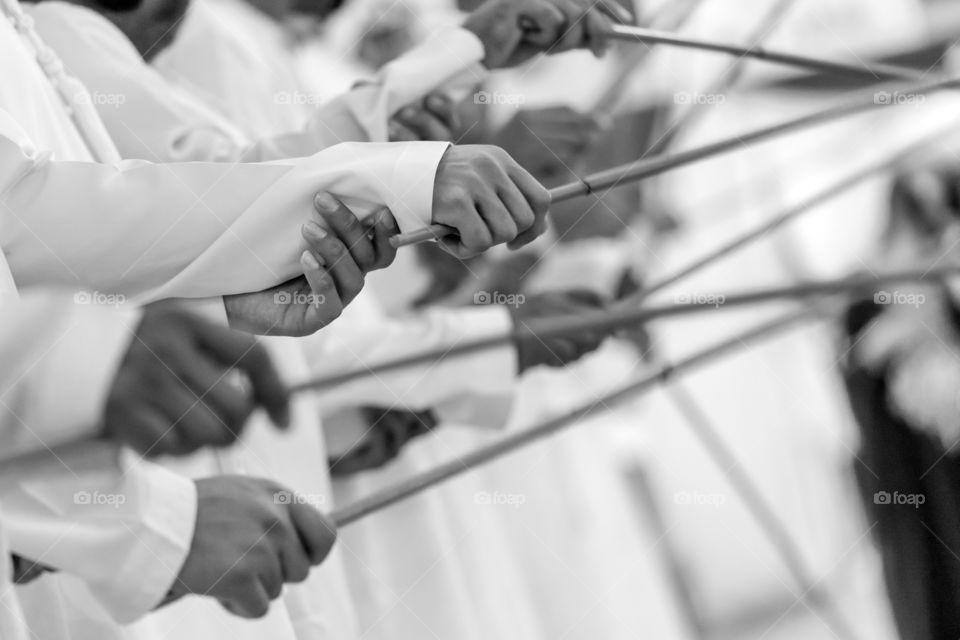 Traditional Emirati male dance, UAE heritage. Hands in frame.