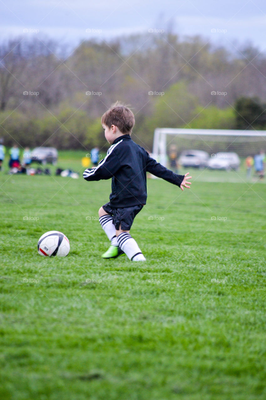 Young boy playing soccer on a field