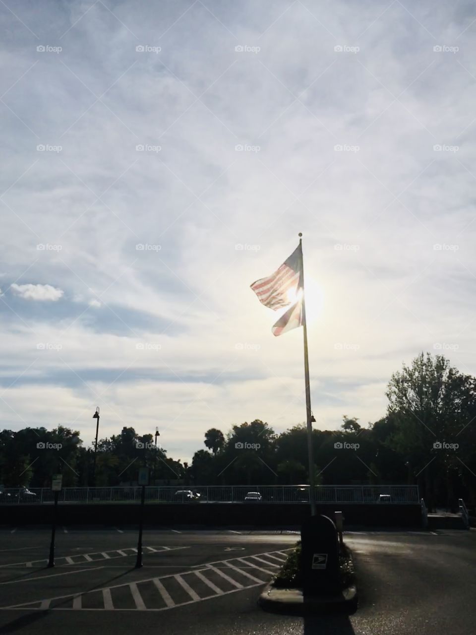 Sun setting behind American and Florida flags 
