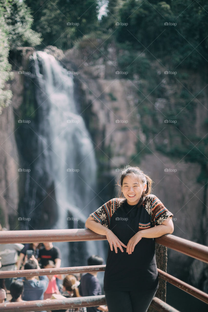 Tourist girl with waterfall in the background 