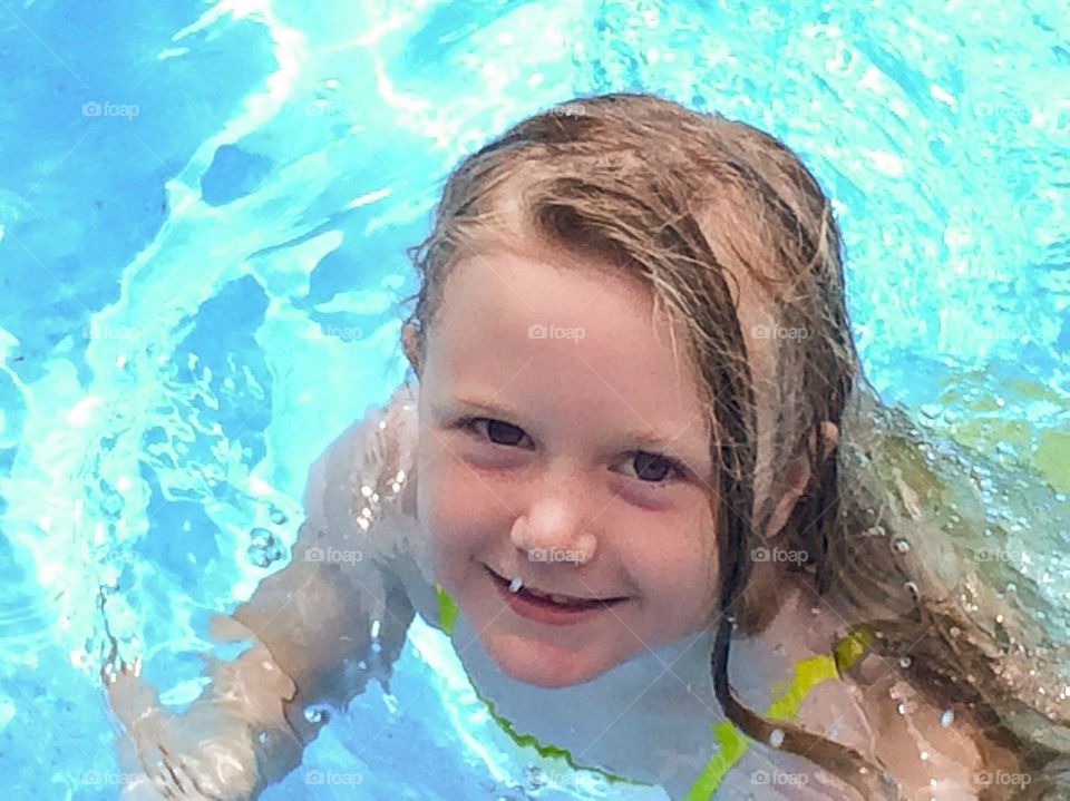 Little girl enjoying in swimming pool