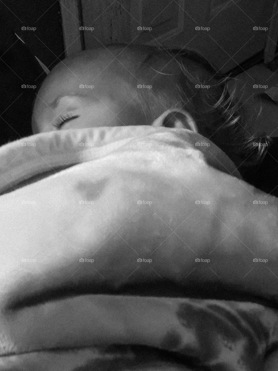 Sleeping baby under blanket black and white image nighttime 