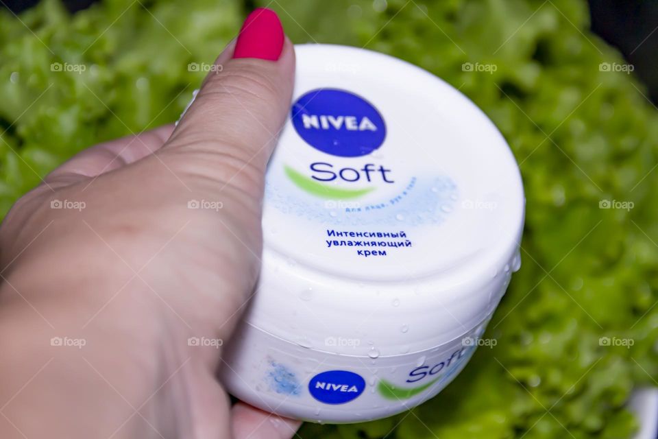 Cosmetic product, Nivea skin care cream on the background of fresh salad with water splashes.