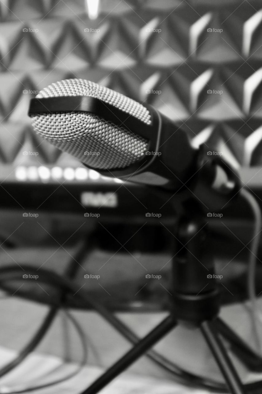 Black and white microphone with the computer screen on background 