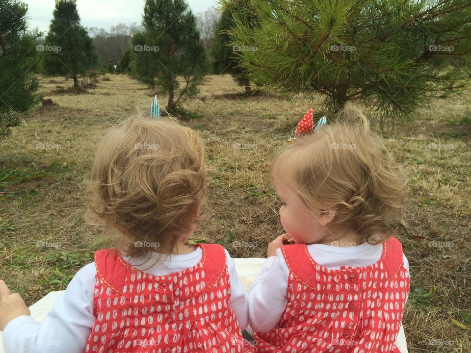 Matching identical twin girls in pine trees
