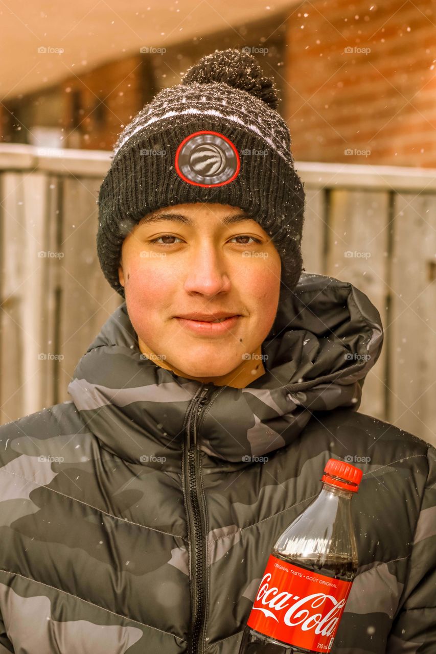 Happy teenager with a bottle of coca cola