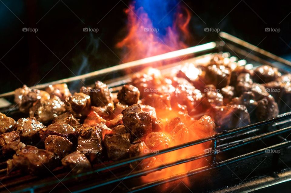 Steak flames up on a grill at a night market in Taiwan. 