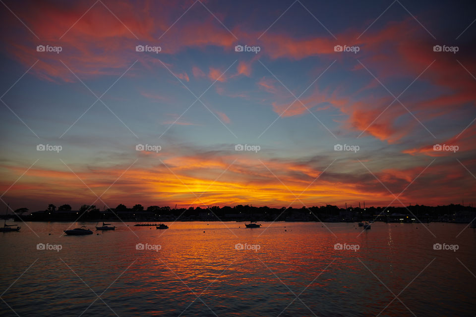 Silhouette of boats in idyllic lake at sunset