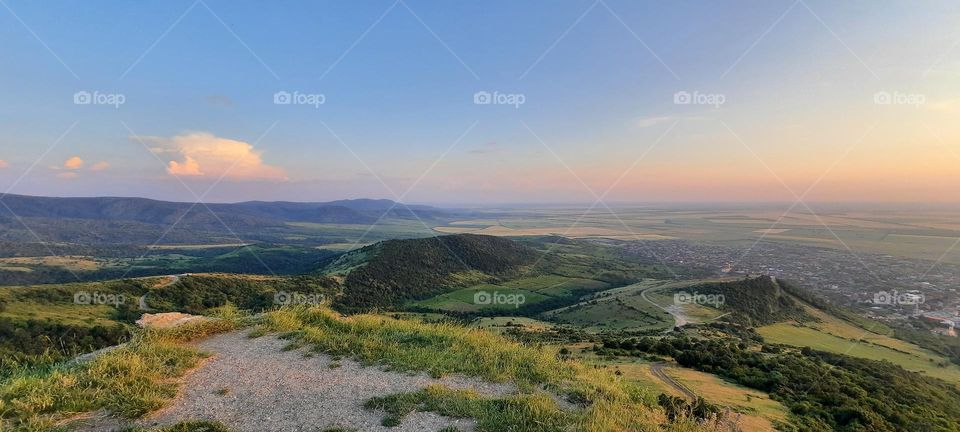 Dramatic sunset sky over green hills