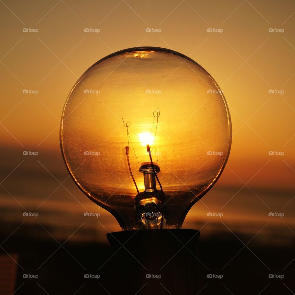 Light bulb on sunset background