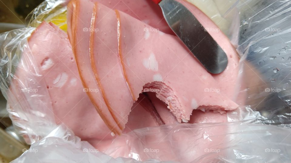 Fatias mordidas, de mortadela.