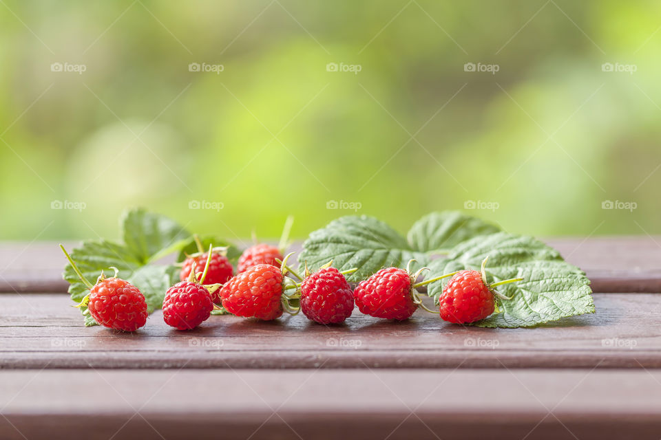 Fresh organic raspberries on wooden background