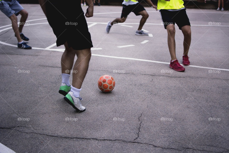 A neighbourhood football tournament. People playing football and children cheering for their favourite team.