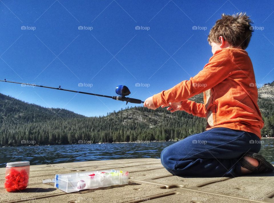 Young Man Fishing In A Mountain Lake. Fishing During The Summer
